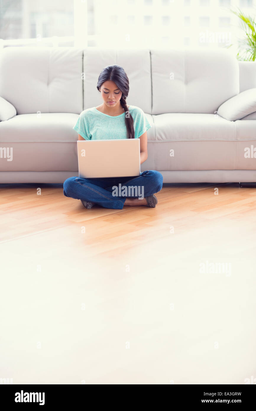 Pretty girl sitting on a floor using laptop Stock Photo - Alamy