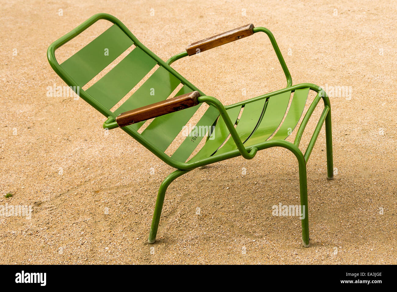 A lone green garden chair with a slanted back sits in the Tuileries garden Paris France Stock Photo