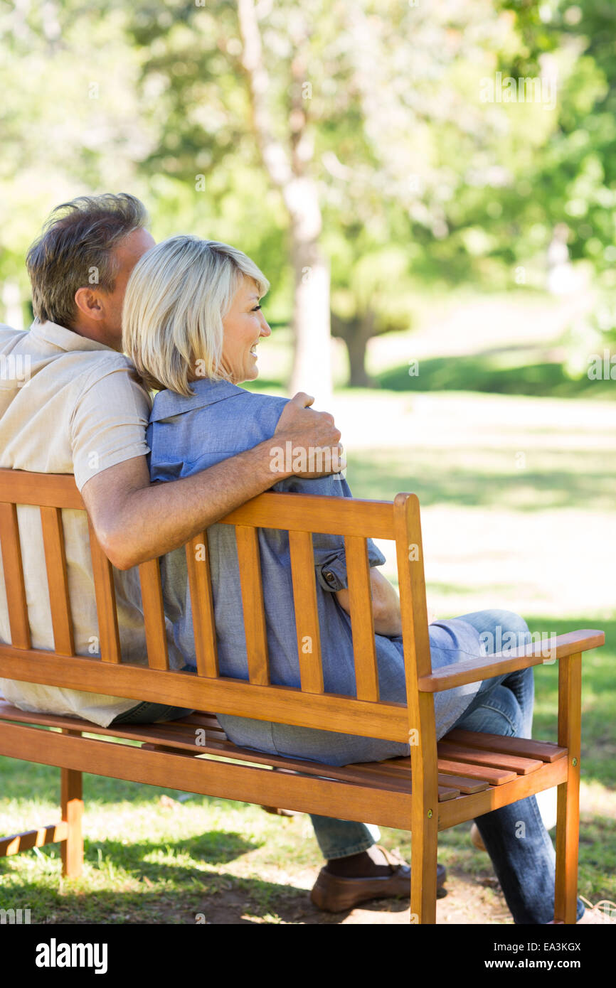 Couple relaxing on park bench Stock Photo - Alamy