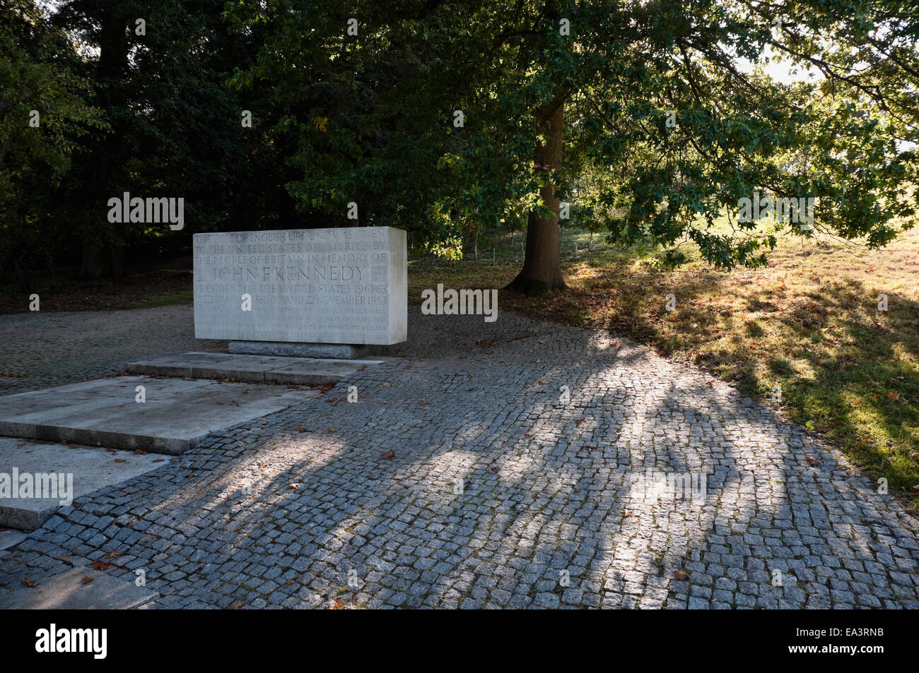 Memorial Stone to John F Kennedy together with an American Scarlet Oak Tree giving dappled light and shade, at Runnymede, UK. Stock Photo