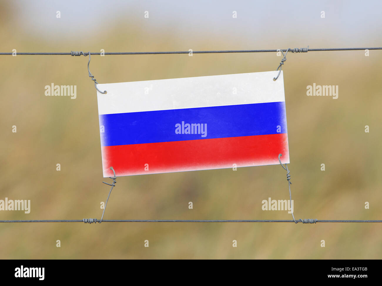 Border fence - Old plastic sign with a flag - Russia Stock Photo