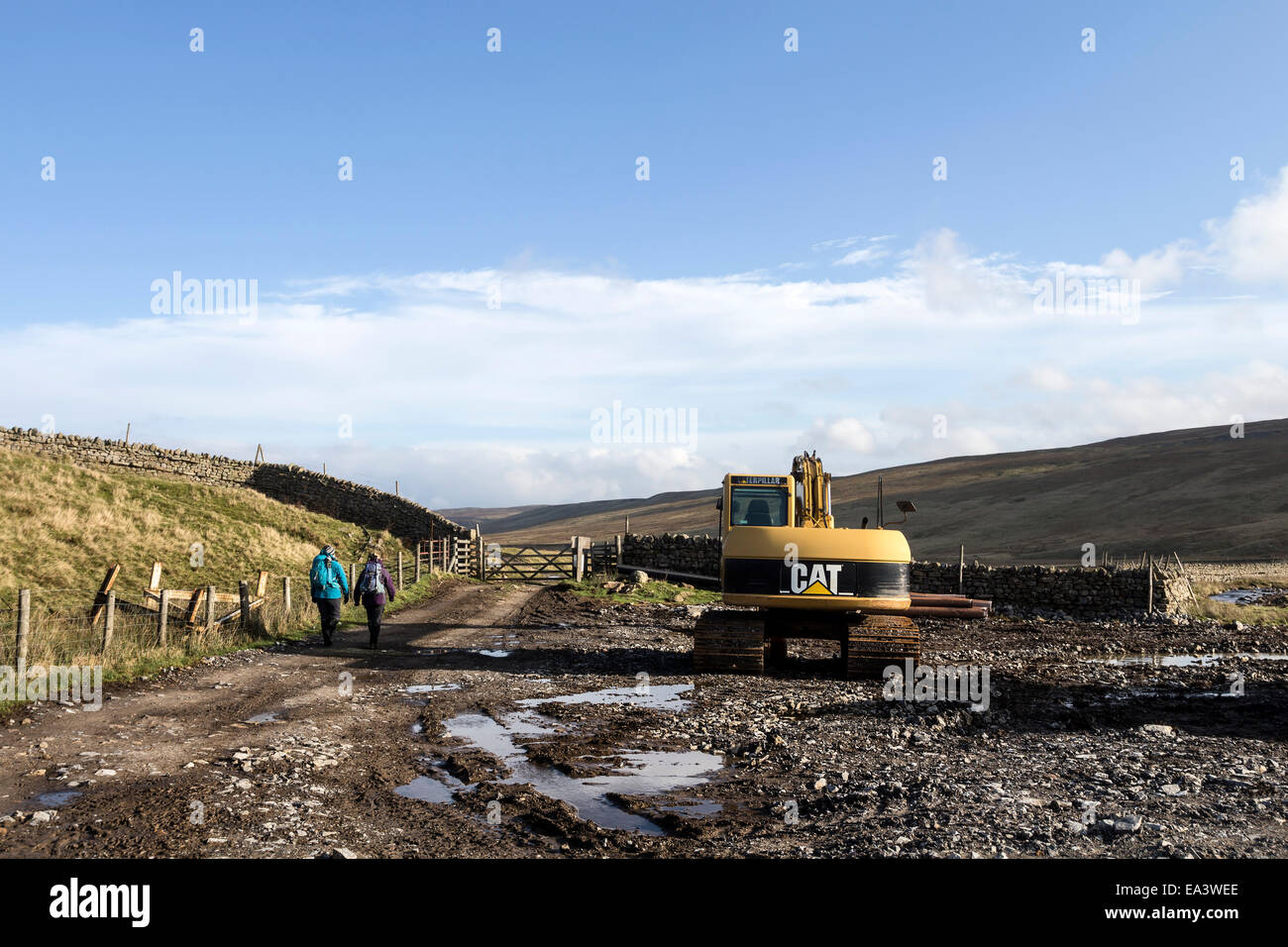 Walkers on a Vehicle Track Created in a Wild and Remote Moorland Setting on a Grouse Moor in Birkdale, Teesdale County Durham UK Stock Photo