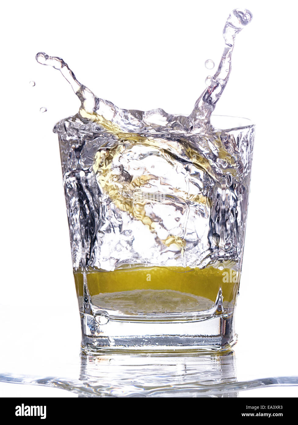 A lemon slice falls in a glass of water Stock Photo