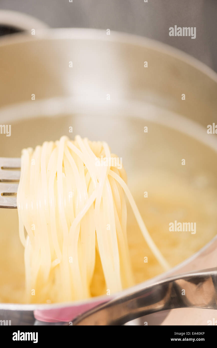 Pan with spaghetti cooking on fork Stock Photo