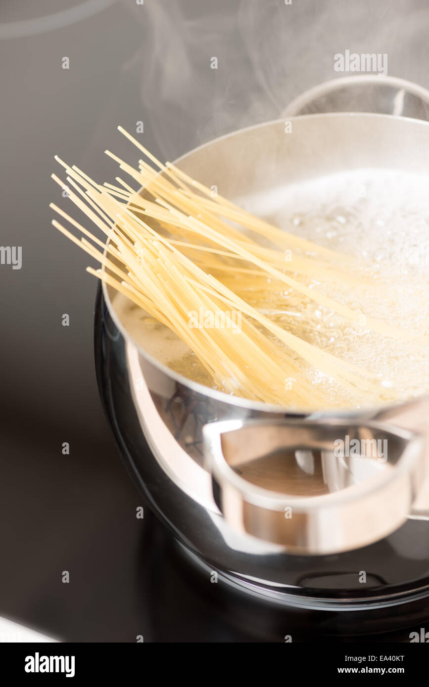 Pan with spaghetti cooking vertical Stock Photo