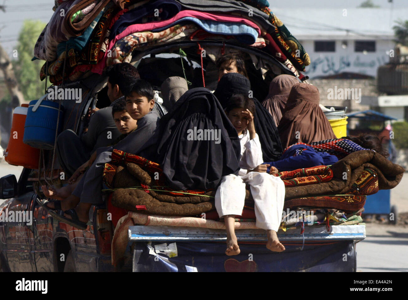Peshawar, Pakistan, 6th November, 2014.  Pakistani tribal families, who fled from neighboring Khyber tribal region due to the fighting between security forces and militants groups, wait for registration at an office on the outskirts of northwest Pakistan's Peshawar on Nov. 6, 2014. Thousands of people have fled from Pakistan's Khyber tribal region due to the fighting between security forces and militants groups. Pakistani security forces have frequently conducted major operations to secure the country's western border with Afghanistan. Credit:  Xinhua/Alamy Live News Stock Photo