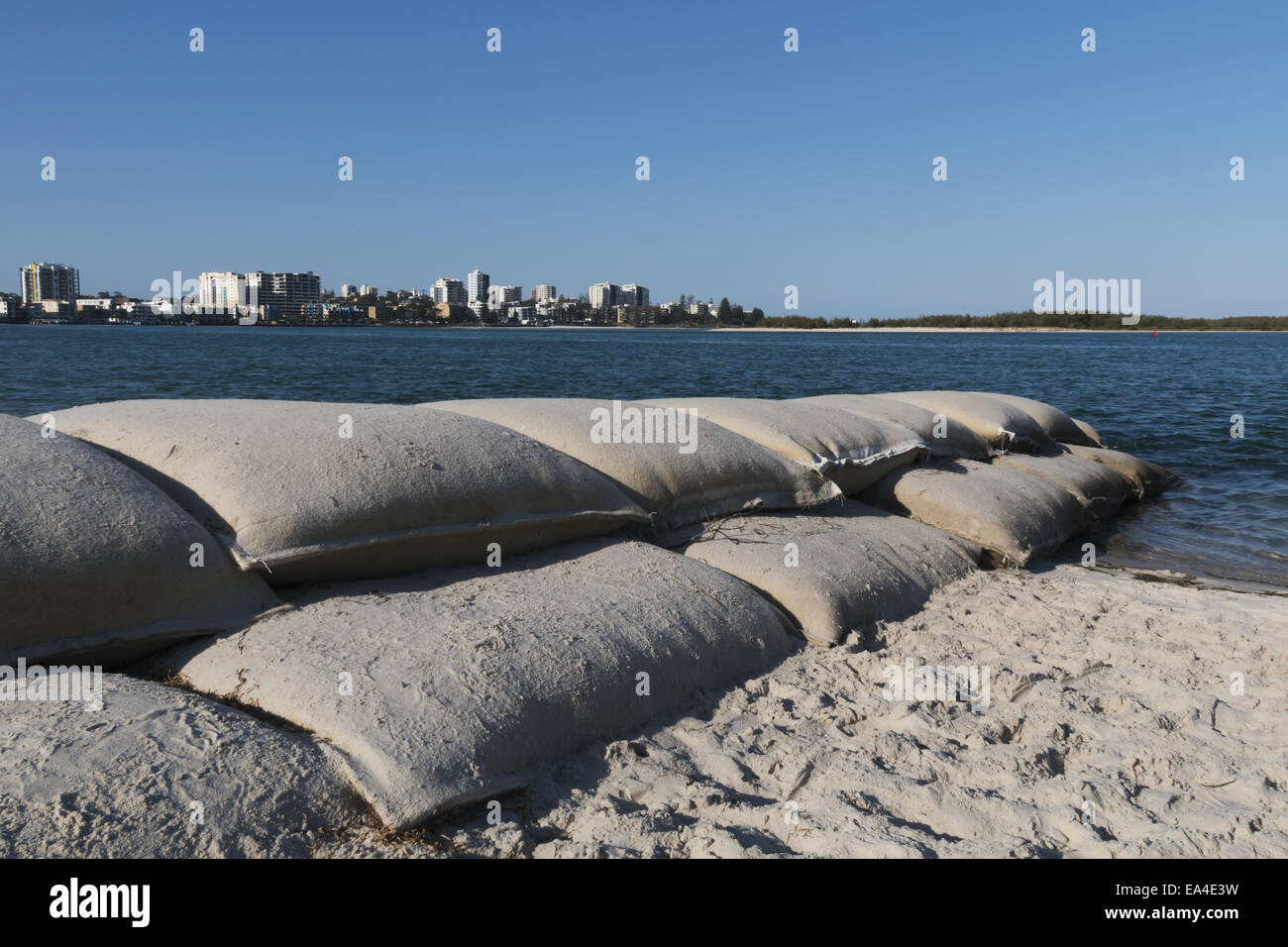Sand bags piled up along the beach to the water's edge; Caloundra
