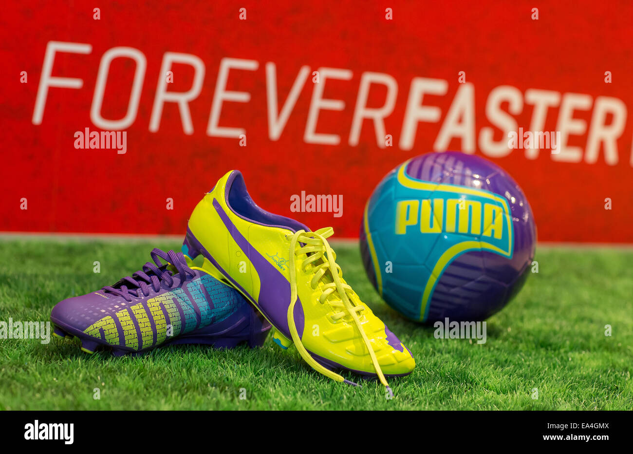 PUMA football boot evoSPEED (l.) and football evoPOWER lying together with  a football on the grass with Forever Faster slogan in the background.  COMMERCIAL HANDOUT/EDITORIAL USE ONLY/NO SALES. Please quote the source 
