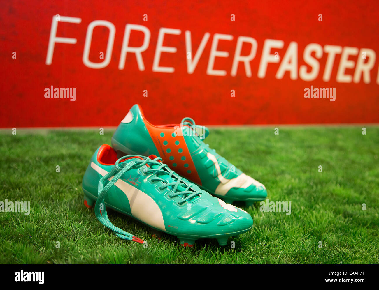 PUMA football boots evoPOWER lying on the grass with Forever Faster slogan  in the background. COMMERCIAL HANDOUT/EDITORIAL USE ONLY/NO SALES. Please  quote the source: "photo: PUMA/Ralf Roedel Stock Photo - Alamy