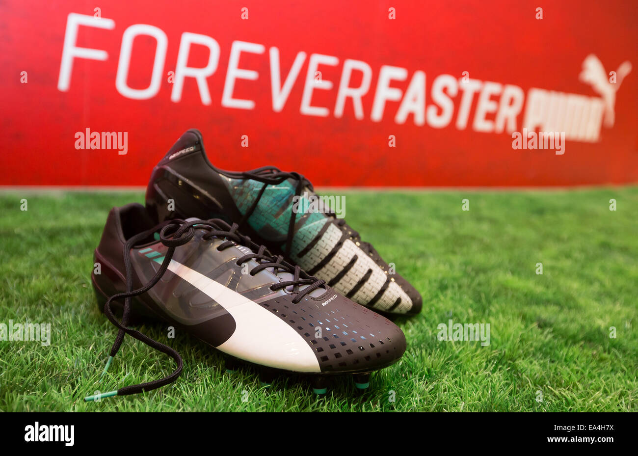 PUMA football boot evoSPEED lying on the grass with Forever Faster slogan and PUMA logo in the background.     COMMERCIAL HANDOUT/EDITORIAL USE ONLY/NO SALES. Please quote the source 'photo: PUMA/Ralf Roedel'.     Stock Photo