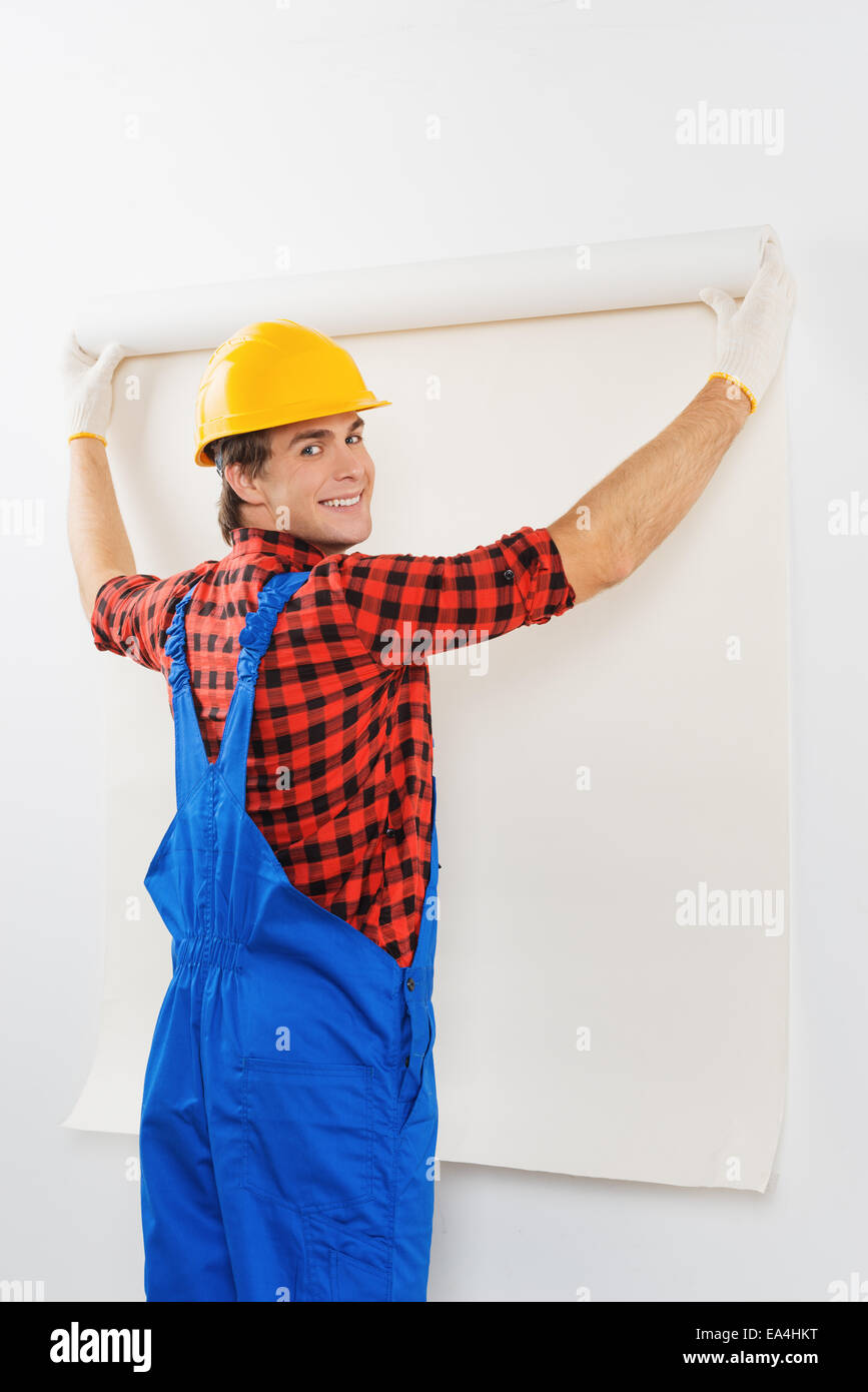 Smiling repairman gluing wallpaper Stock Photo