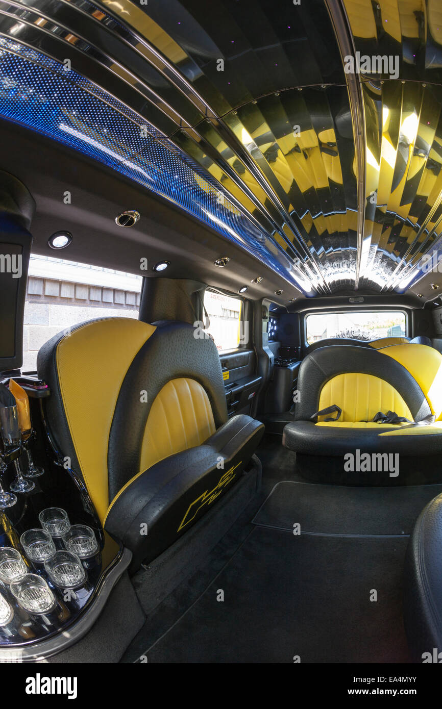 The interior of a luxury limousine with black and yellow leather seats