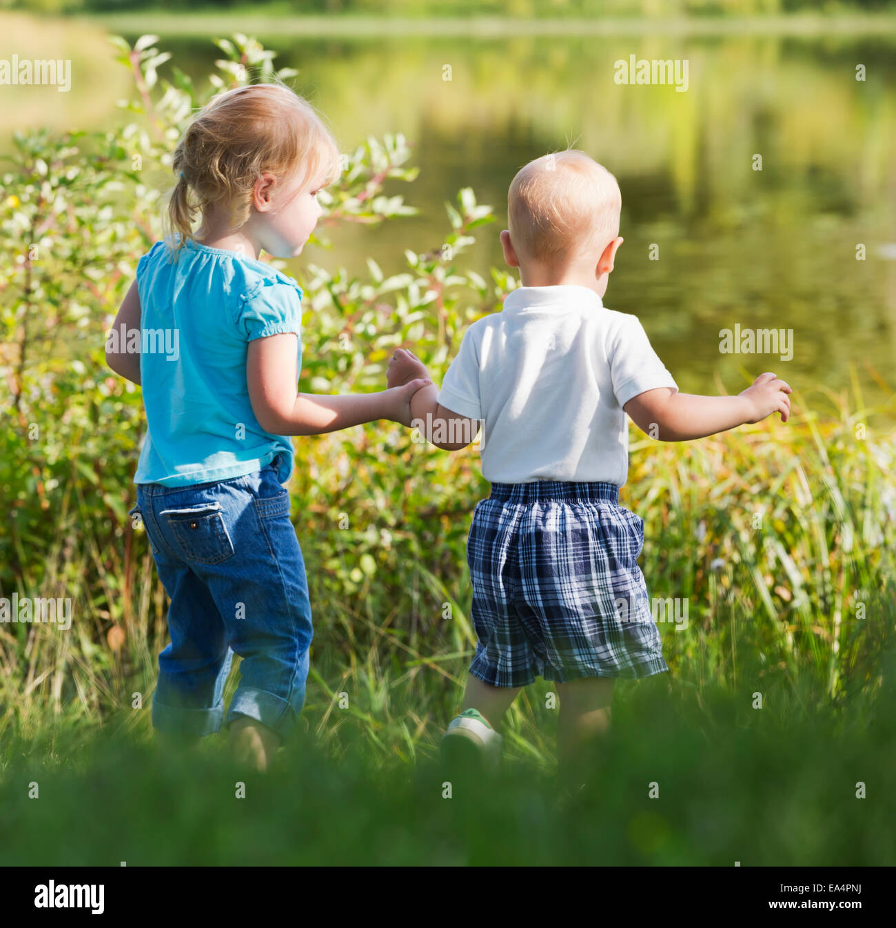 Young brother and sister walking together on shore; Edmonton, Alberta, Canada Stock Photo