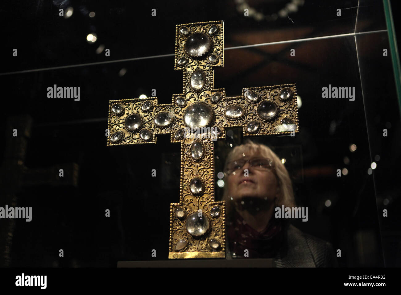 Prague, Czech Republic. 6th November 2014. A visitor examines a Romanesque reliquary procession cross during a press preview to the exhibition The Benedictines in the Heart of Europe in the National Gallery in Prague, Czech Republic. The exhibition entitled Open the Gate of Paradise presents an excellent selection of early medieval artefacts from year 800 to 1300. This reliquary procession cross from Roudnice was made in Prague or Swabia in the middle of the 12th century and now belongs to the Lobkowicz Collection. Stock Photo