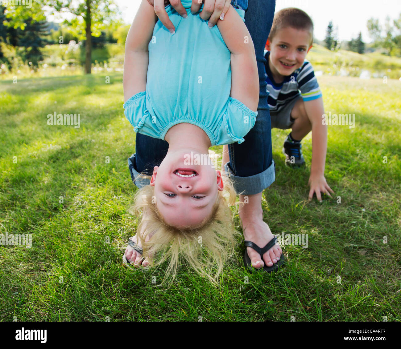 Mother hanging her daughter upside down in a park; Edmonton, Alberta, Canada Stock Photo