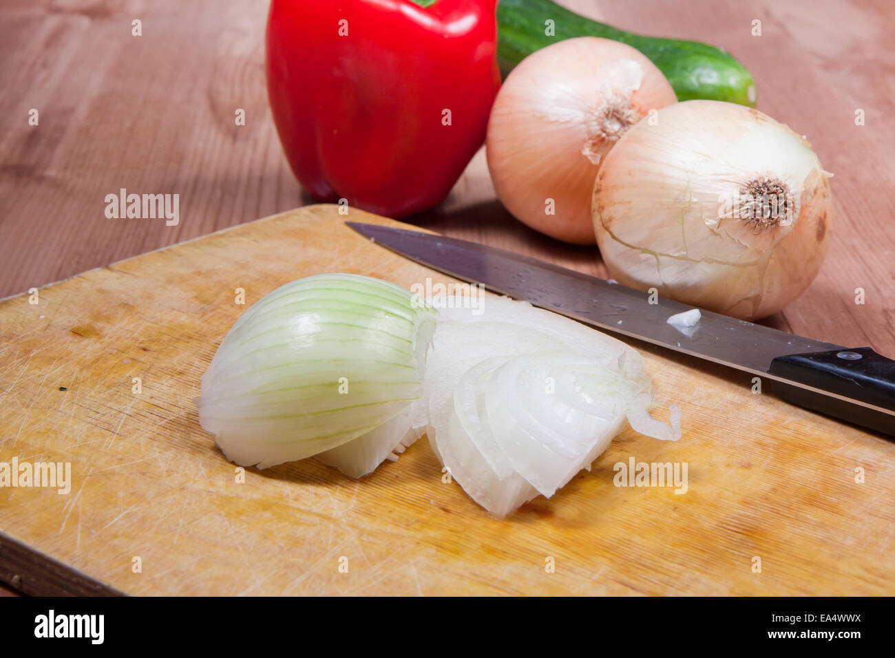 Peeled and sliced onion laying on a cutting board. Stock Photo