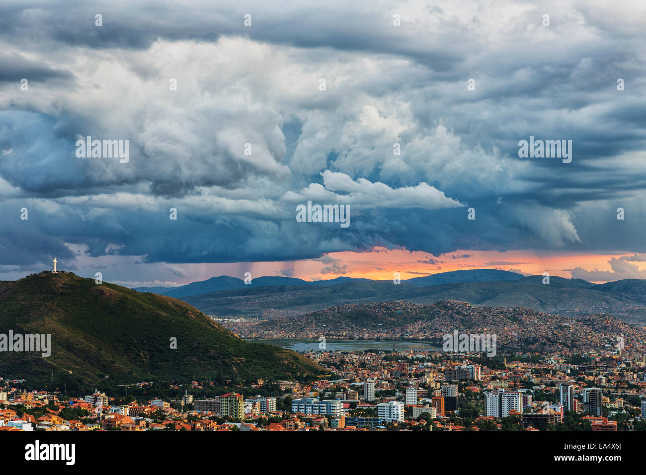 The skies turn stormy over the skies of Cochabamba, with El Cristo seen on the mountain in the middle of the city; Bolivia Stock Photo