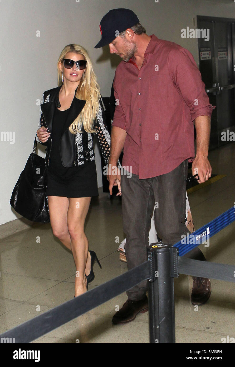 Jessica Simpson in short black skirt and leather jacket, arrives at Los Angeles International Airport (LAX) holding hands with with partner Eric Johnson  Featuring: Jessica Simpson,Eric Johnson Where: Los Angeles, California, United States When: 04 May 20 Stock Photo