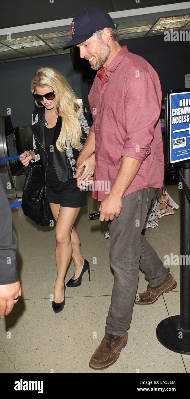 Jessica Simpson in short black skirt and leather jacket, arrives at Los Angeles International Airport (LAX) holding hands with with partner Eric Johnson  Featuring: Jessica Simpson,Eric Johnson Where: Los Angeles, California, United States When: 04 May 20 Stock Photo