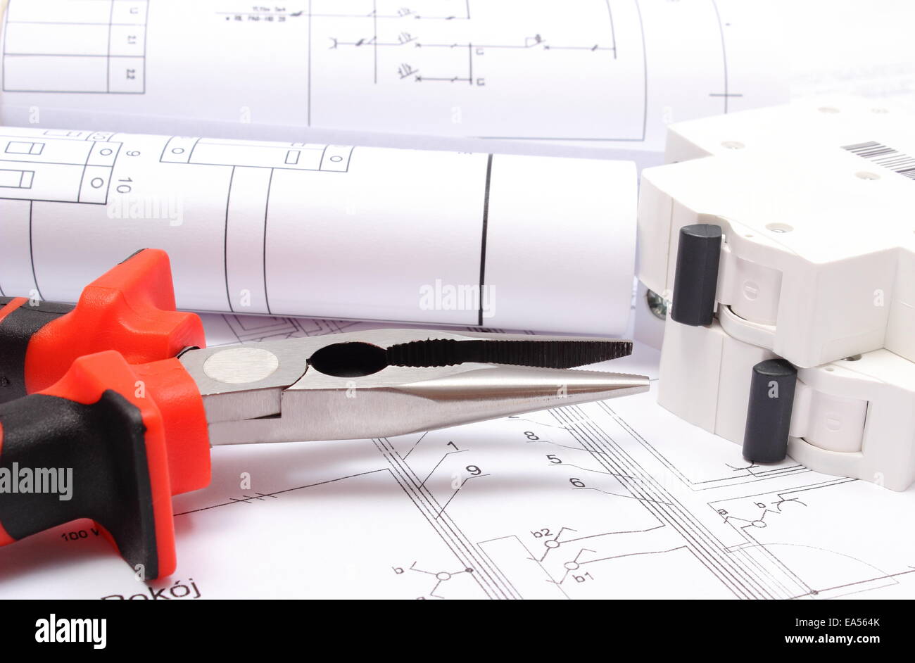 Rolled electrical diagrams, electric fuse and work tools lying on construction drawing of house, drawings for the projects engin Stock Photo