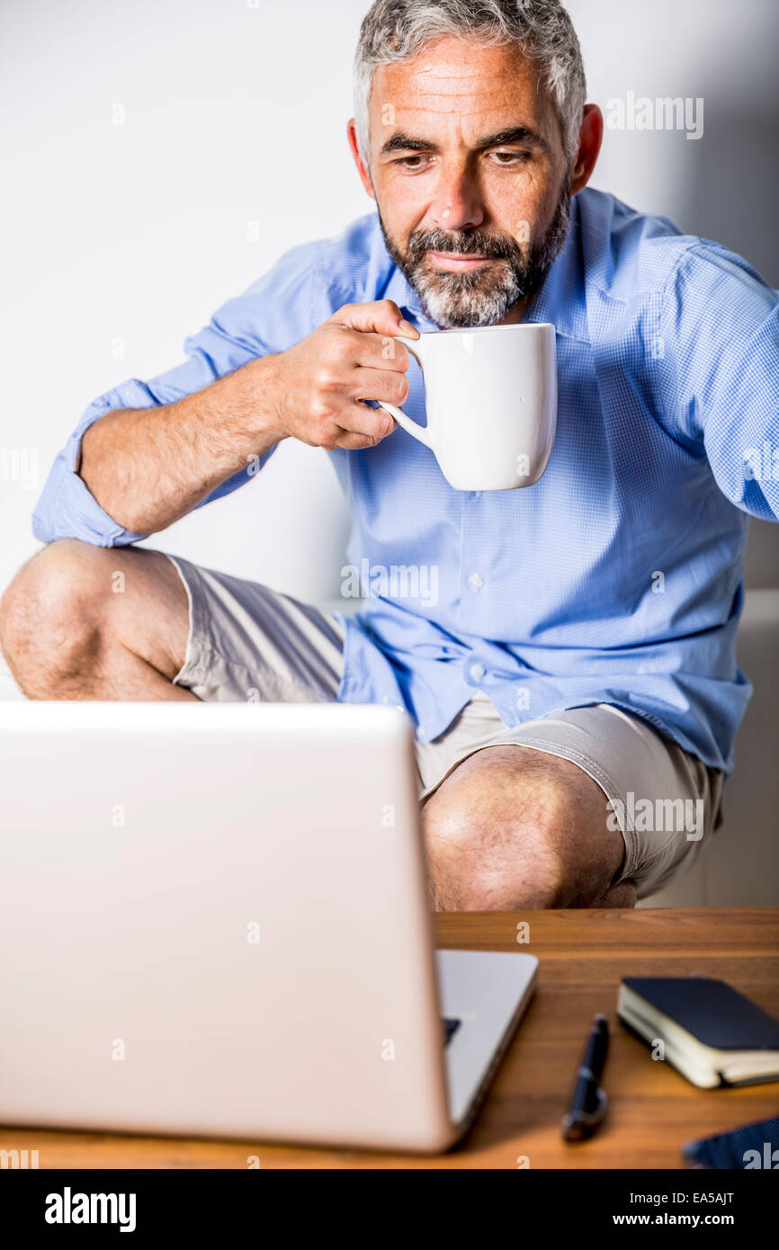 Potrait of businessman having a coffee break at his home office Stock Photo