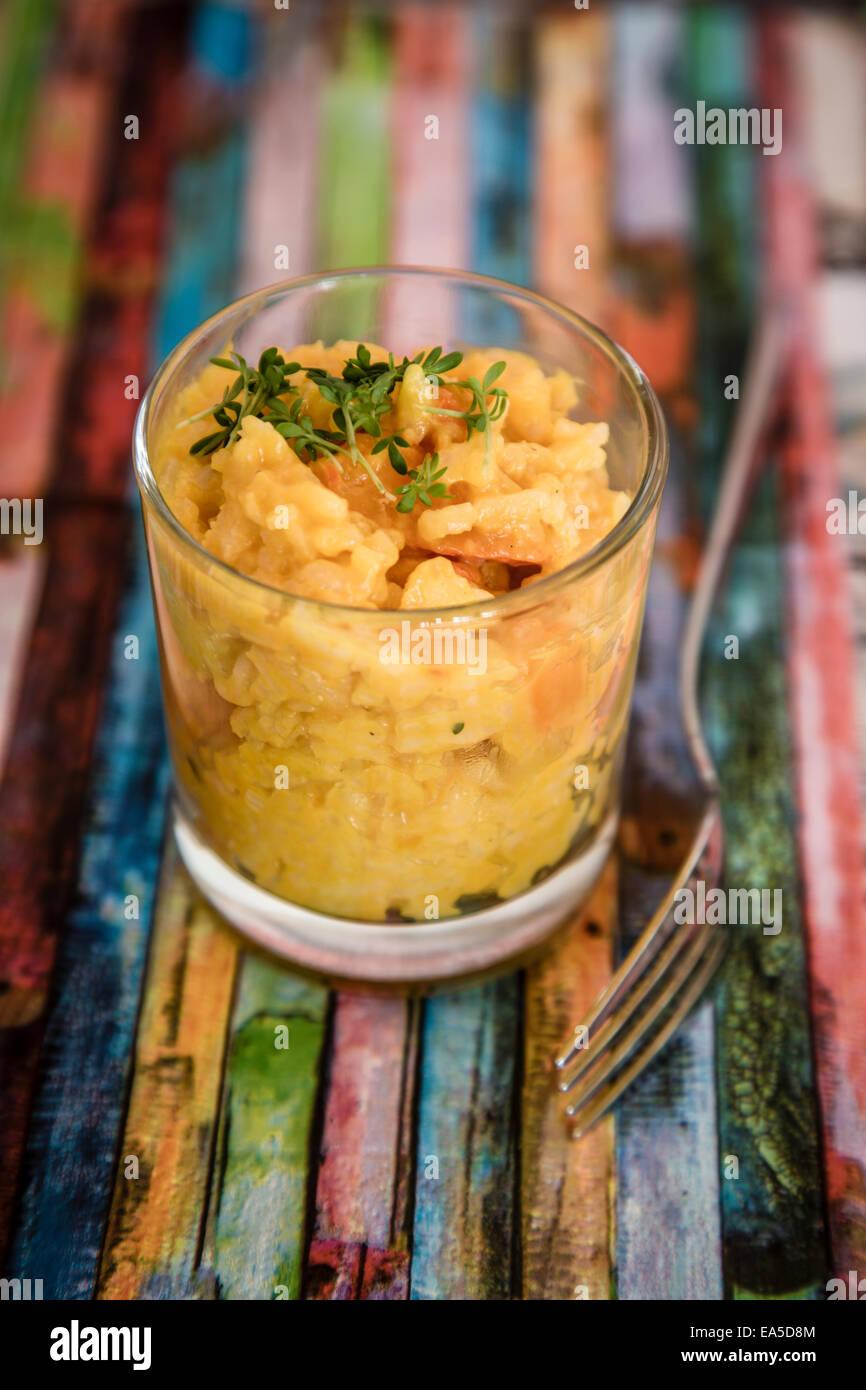 Glass of pumpkin risotto garnished with cress Stock Photo