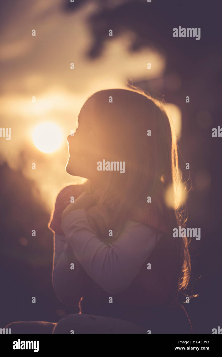 Silhouette of little girl at evening backlight Stock Photo