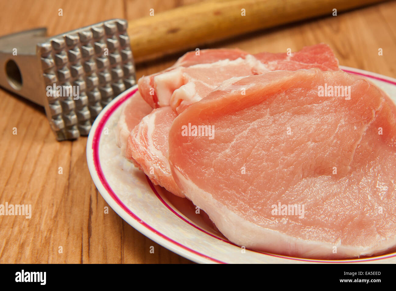 Sliced pork chops  and a kitchen hammer. Stock Photo