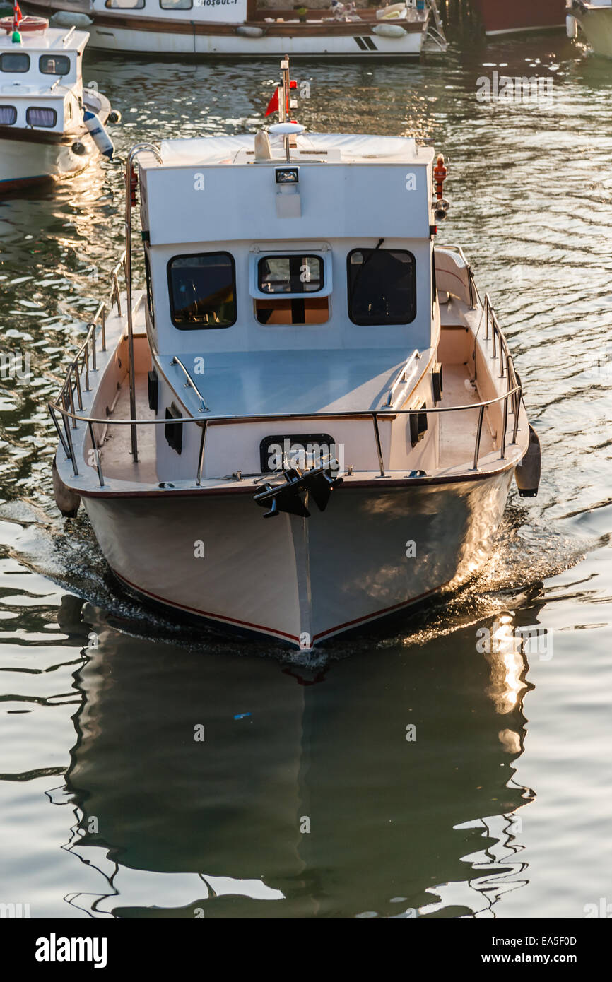 Boats just before sunset with reflections on the sea Stock Photo - Alamy