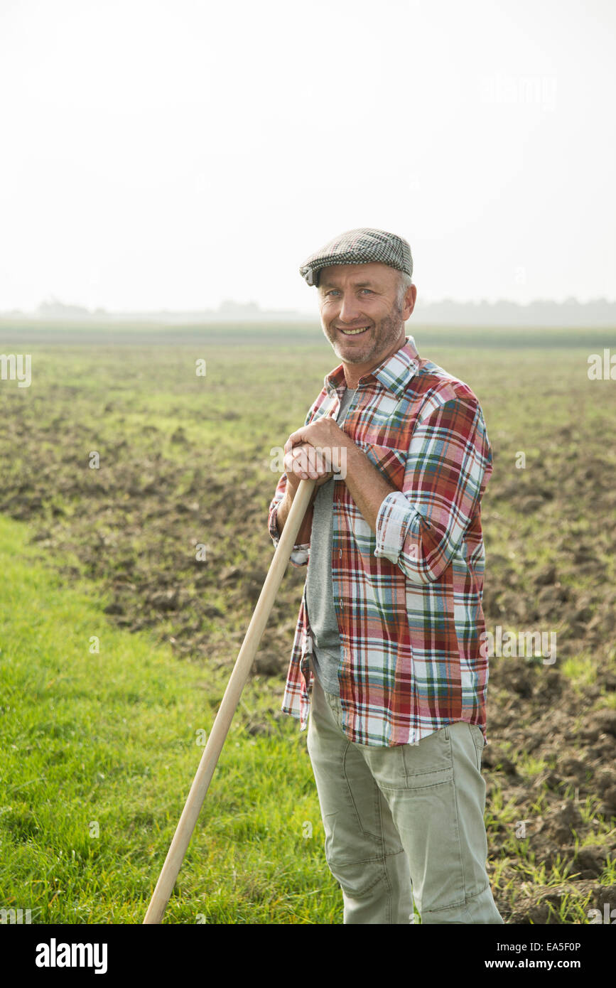 Smiling farmer standing in front of a field Stock Photo - Alamy