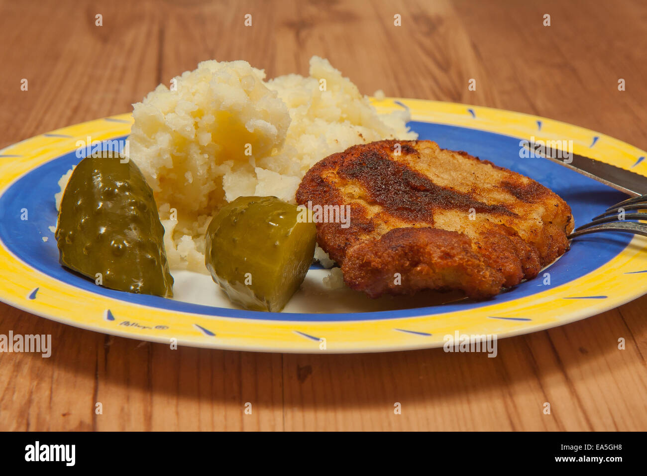 Dinner ready.  Fried pork chop with potatoes and cucumber pickle Stock Photo