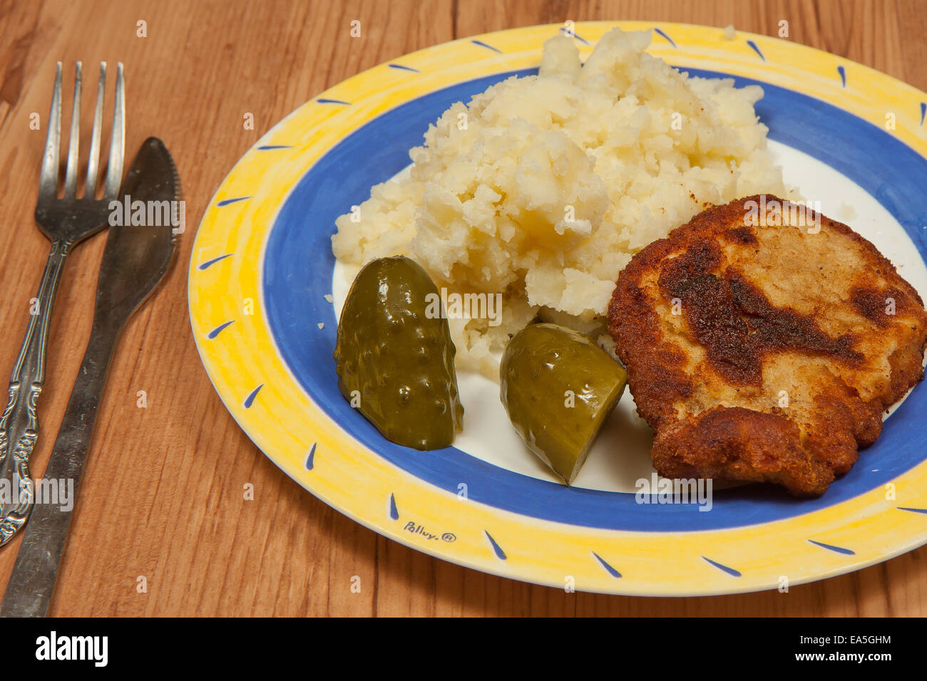 Dinner ready.  Fried pork chop with potatoes and cucumber pickle Stock Photo
