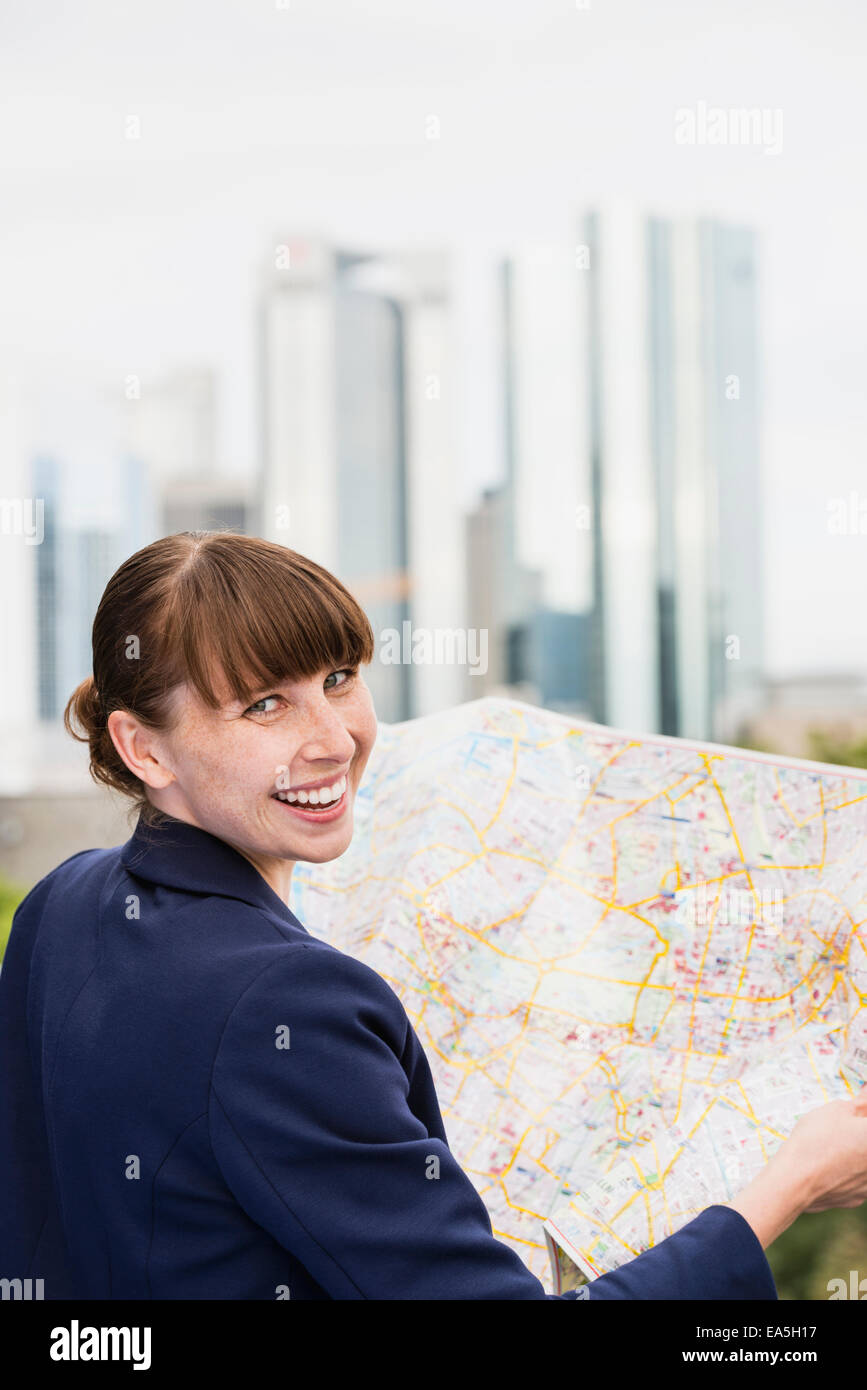 Germany, Hesse, Frankfurt, portrait of smiling woman with city map Stock Photo