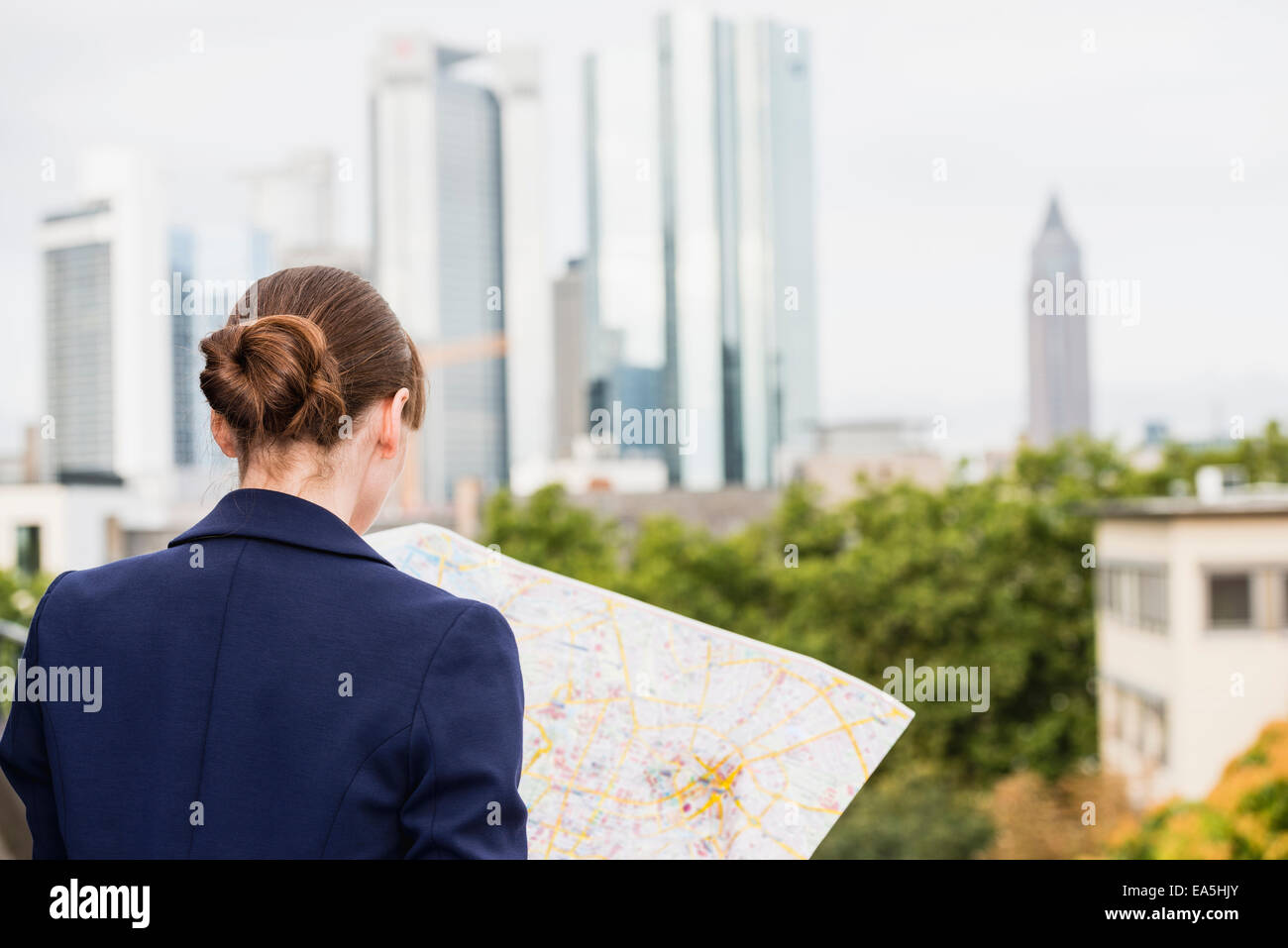 Germany, Hesse, Frankfurt, woman looking at city map, back view Stock Photo