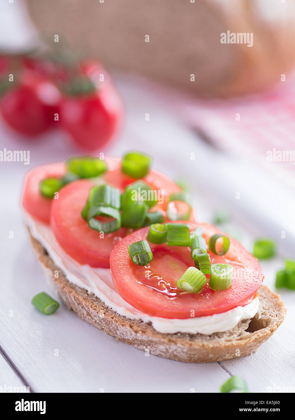 A slice of bread filled with tomato slices. Stock Photo