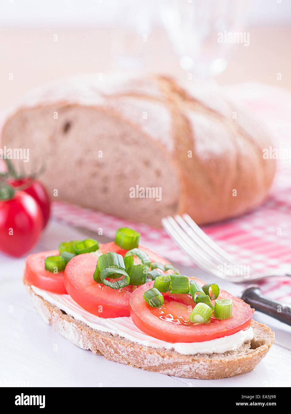 A slice of bread filled with tomato slices. Stock Photo