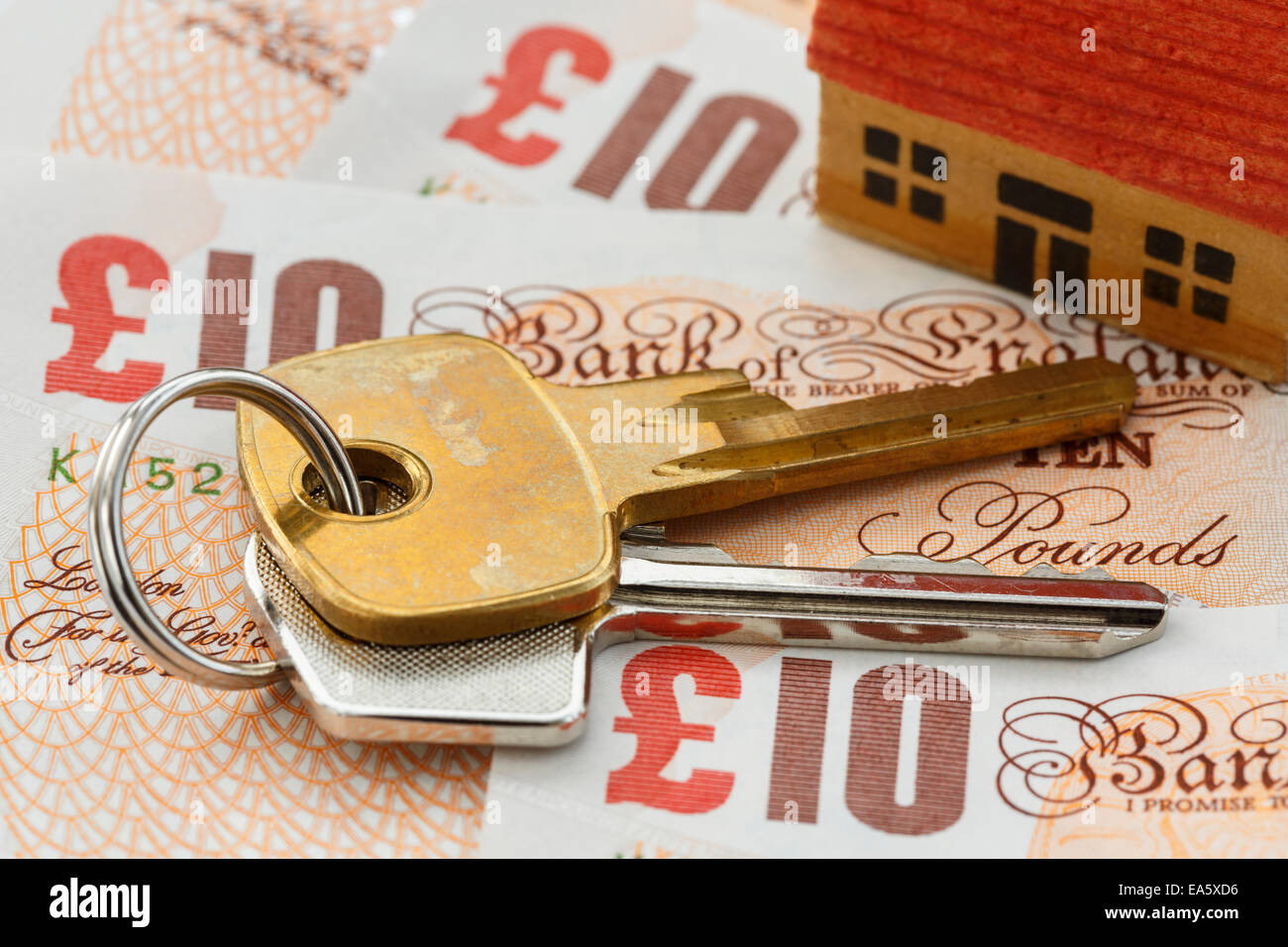 House keys on English money sterling ten pound notes GBP to illustrate UK property tax investment prices savings concept in England UK Britain Stock Photo