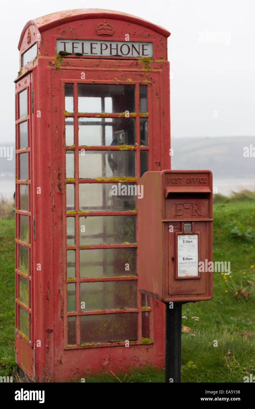 A weathered red post box and telephone box stand near the Tywi Estuary at Llansteffan, Carmathenshire, Wales, UK Stock Photo
