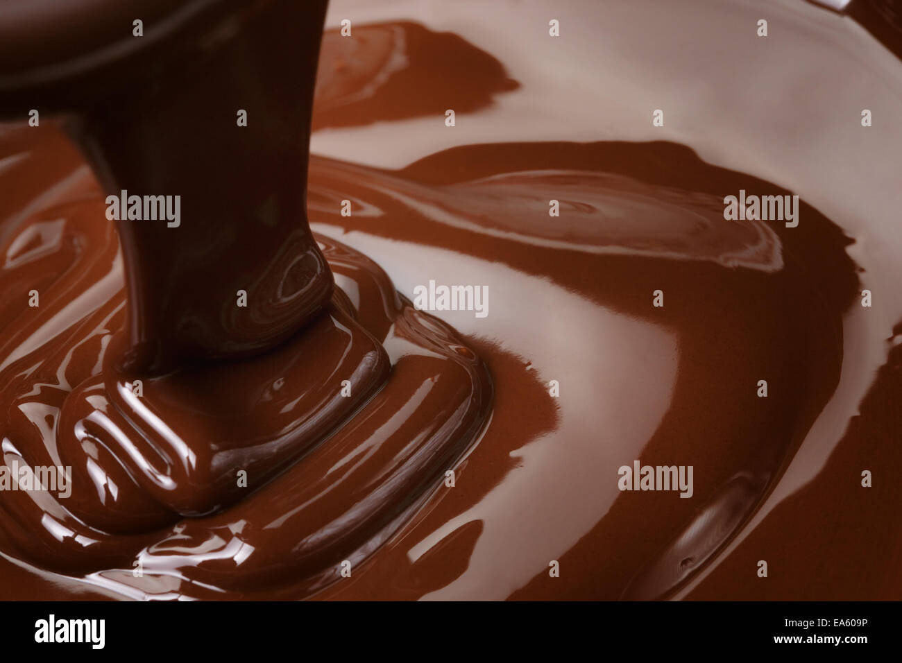 melted dark chocolate flow, candy or chocolate preparation background Stock Photo