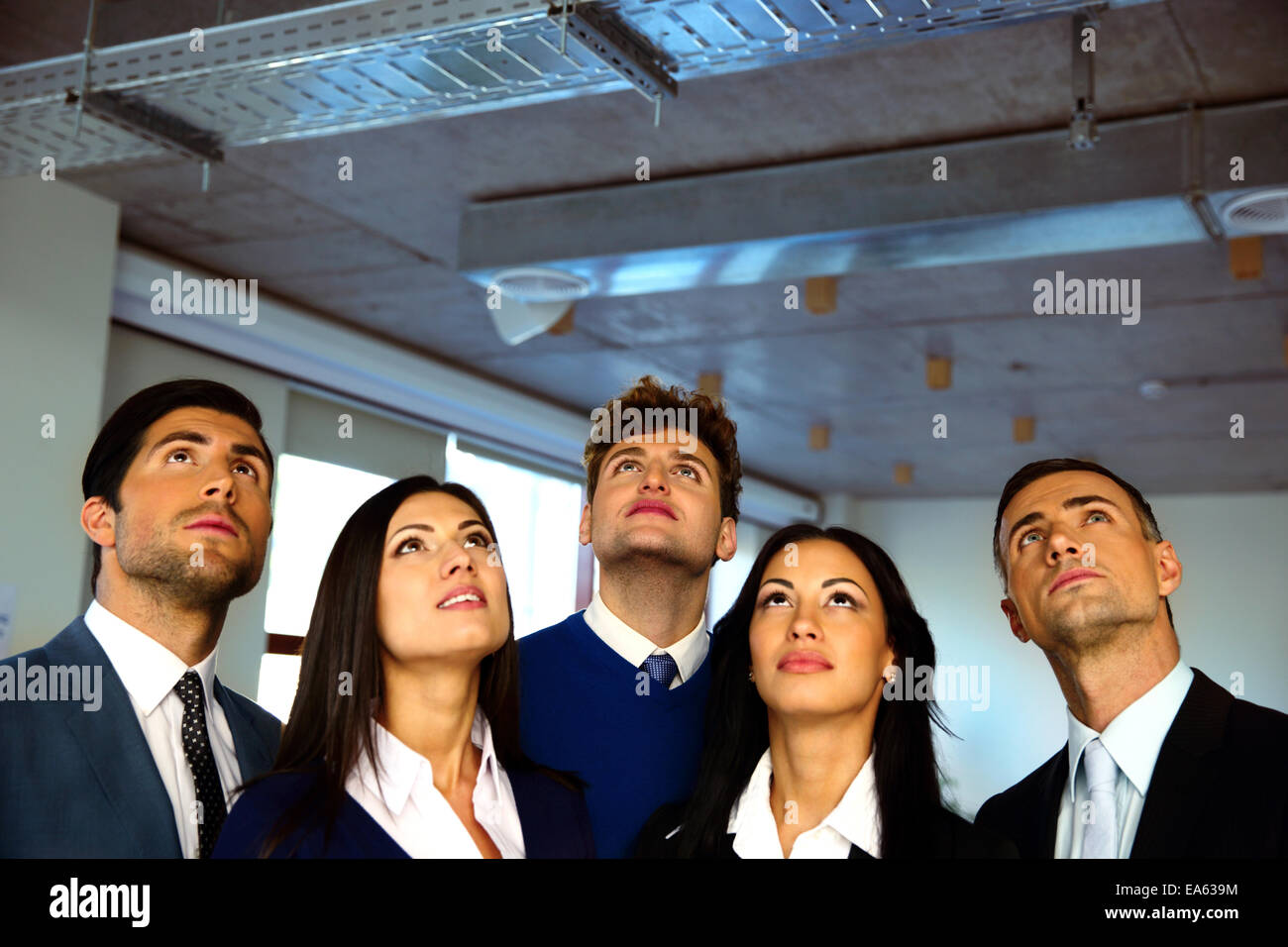 Serious business people looking up with dreaming expression Stock Photo