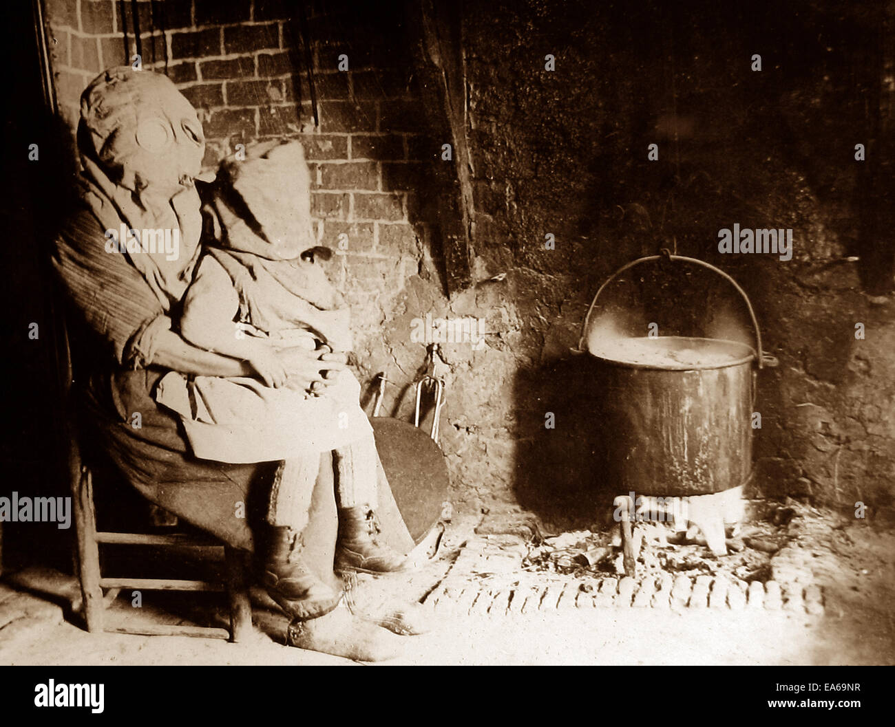 Belgian peasant and child wearing gas masks in their home near the trenches on the Flanders Front WW1 Stock Photo