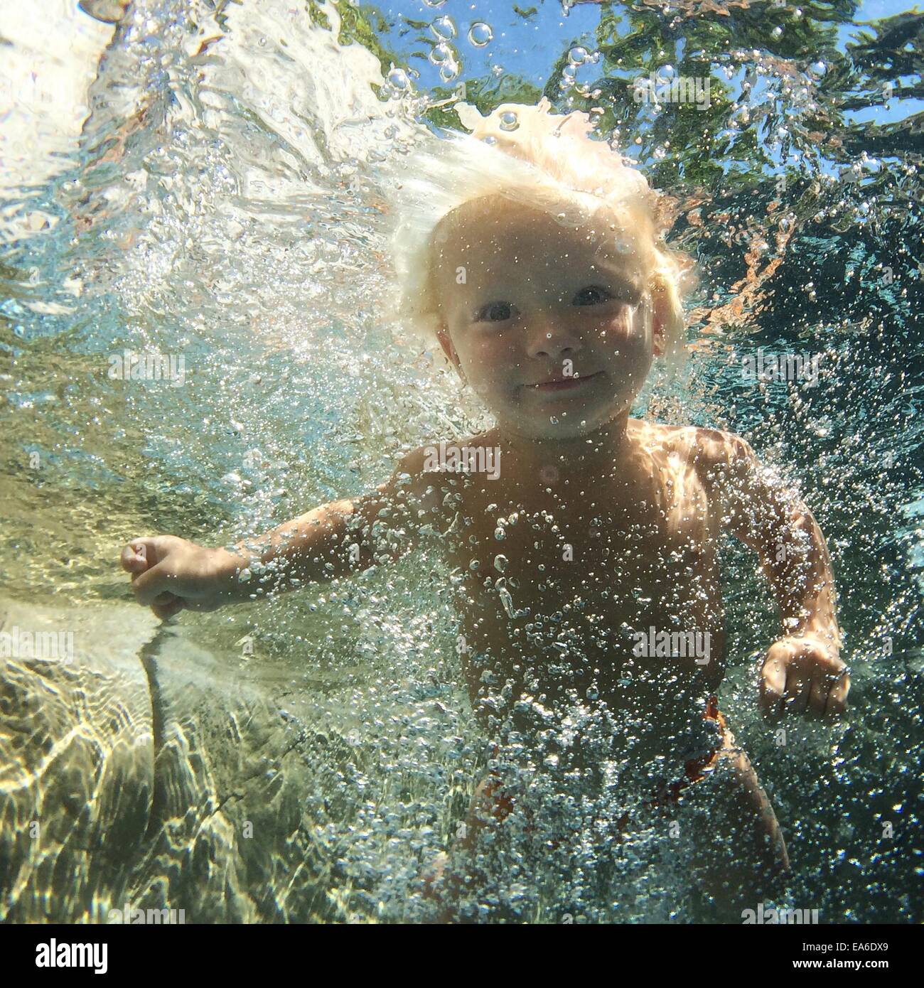 Boy swimming underwater in swimming pool Stock Photo