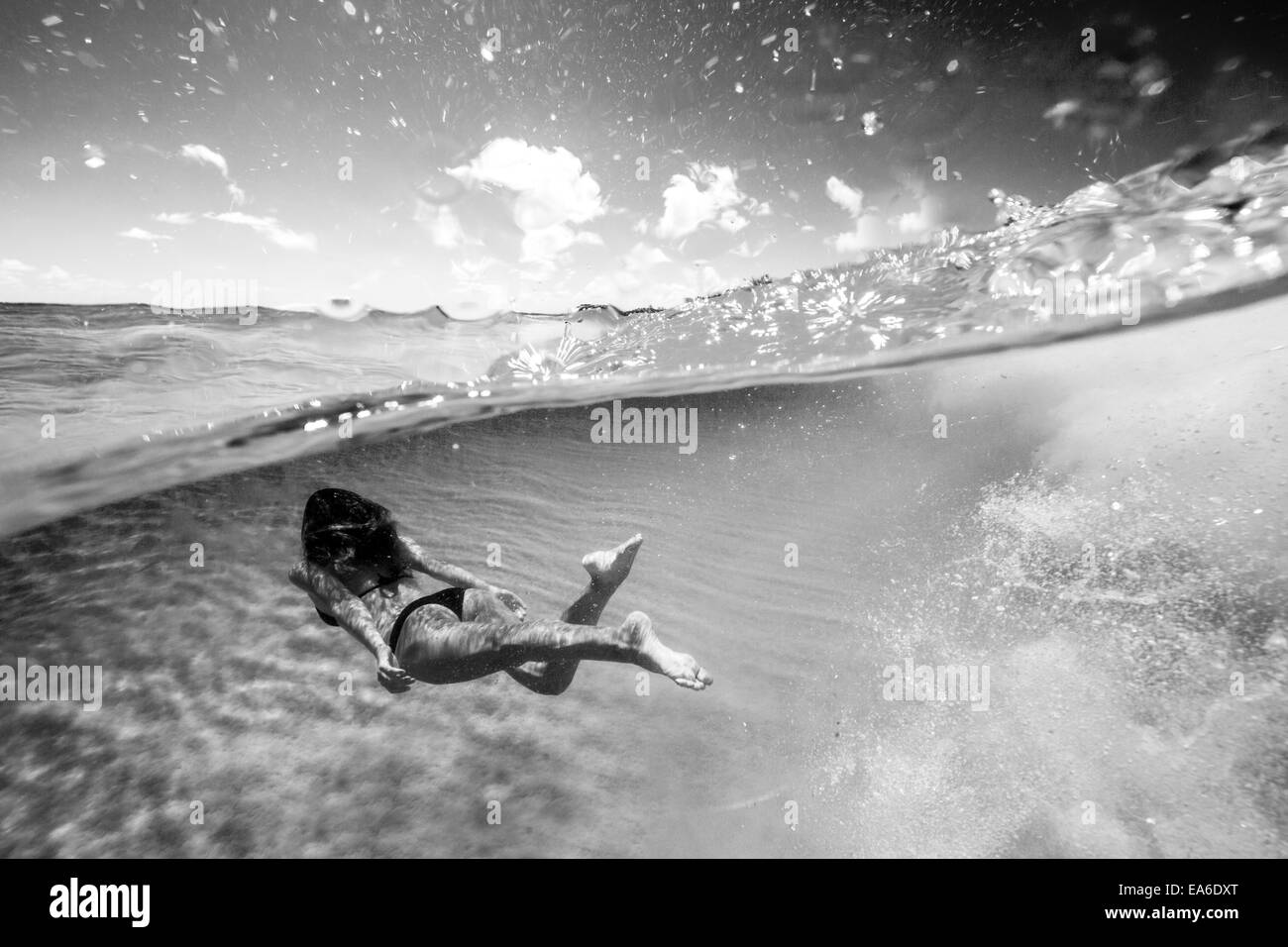 Woman swimming underwater in the ocean Stock Photo