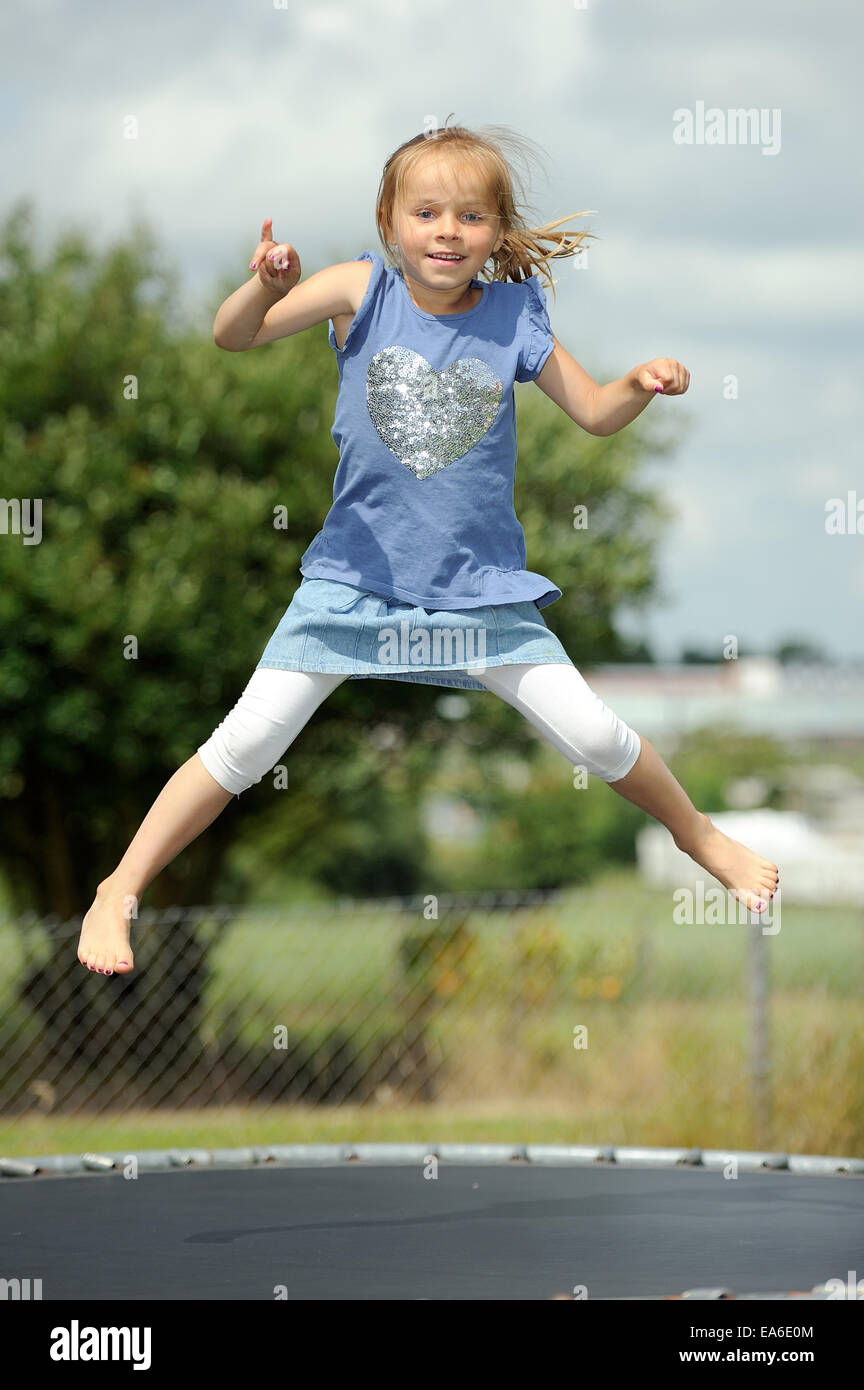 Italia, Calabria, Girl (2-3) jumping on trampoline in summer Stock Photo