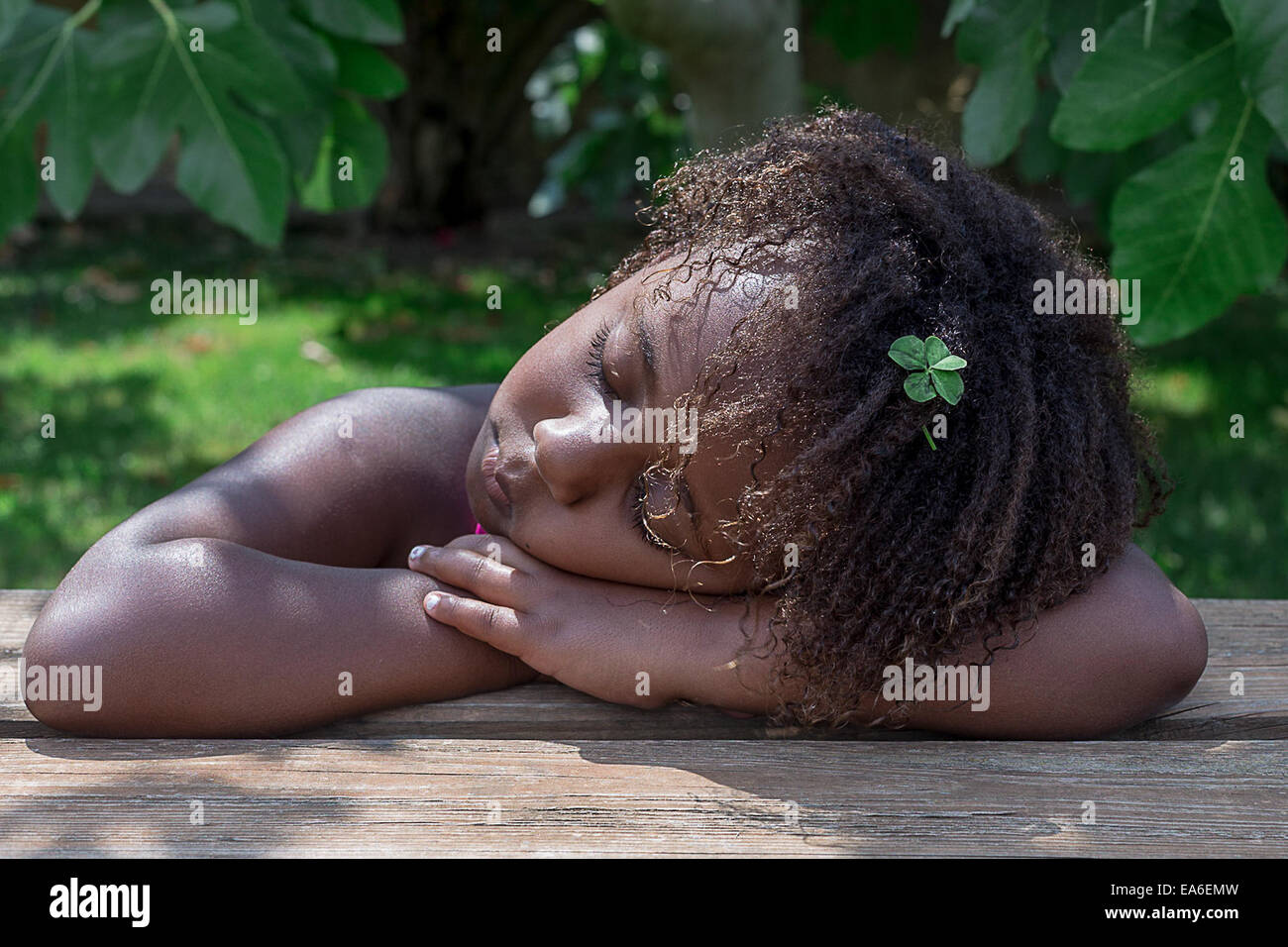 Young girl napping with her head resting on table Stock Photo
