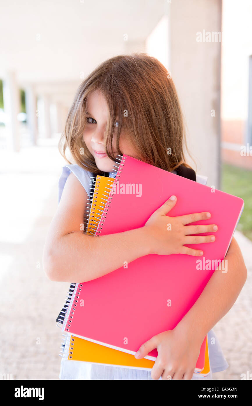 Little cute girl holding books at school Stock Photo - Alamy