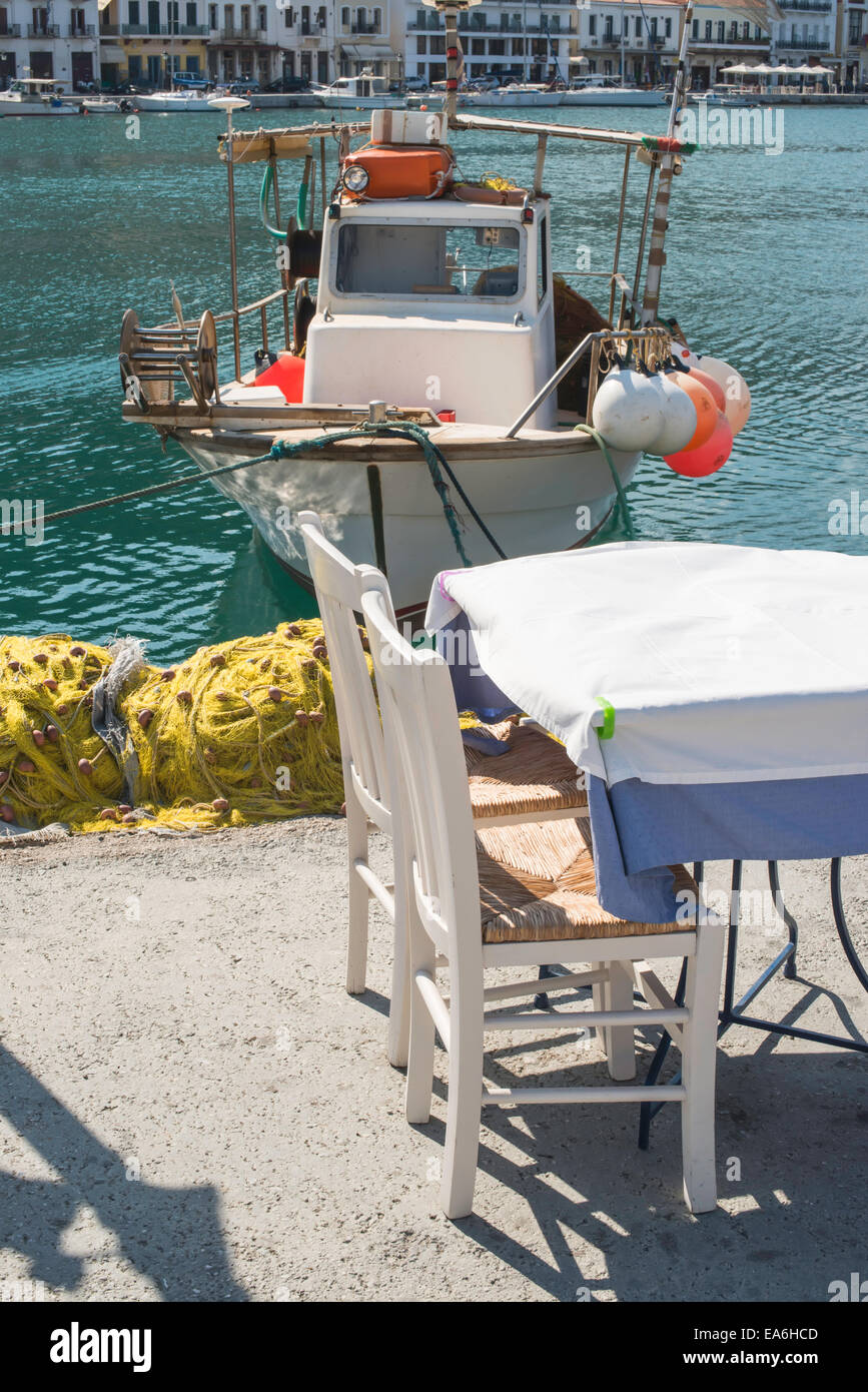 Typical greek restaurant and fish boat on the background Stock Photo