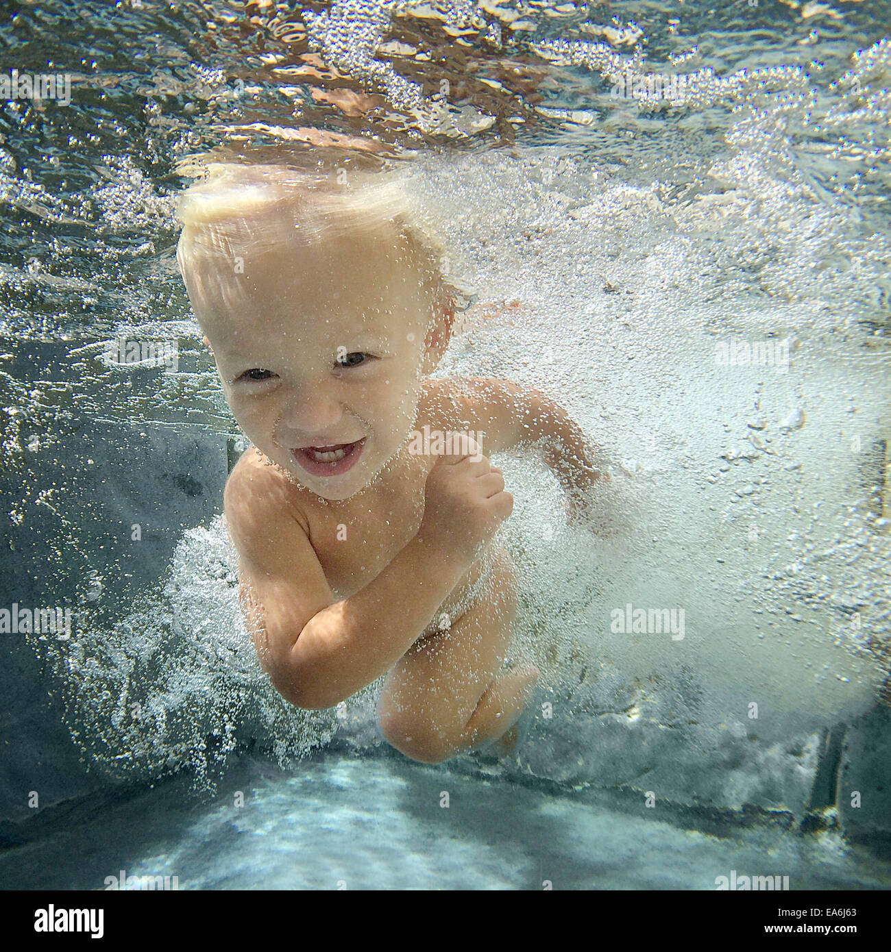 Boy swimming underwater in a swimming pool Stock Photo