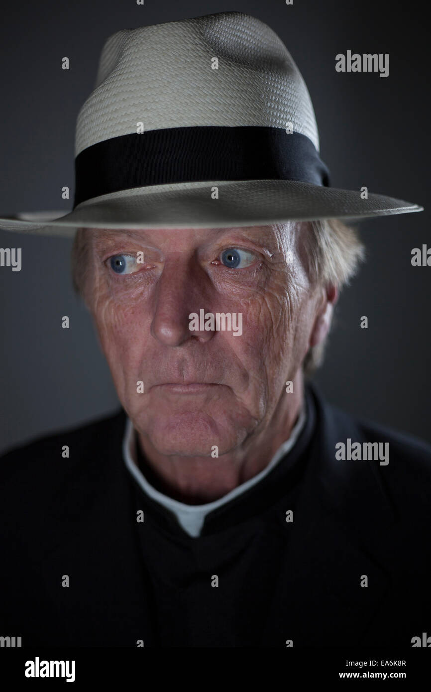 A white european male age 50 plus wearing religious clothing and smoking a cigarette Stock Photo