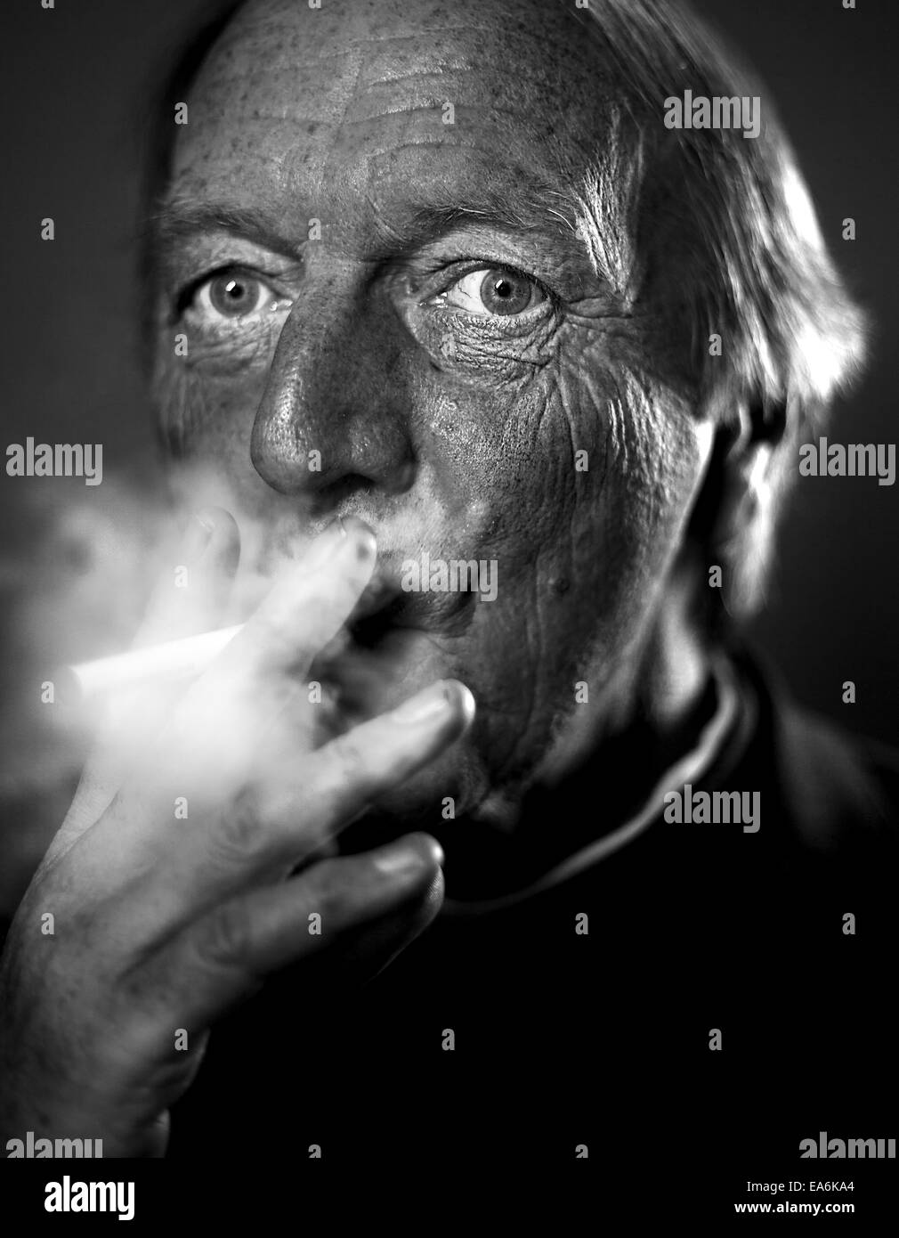 A white european male age 50 plus wearing religious clothing and smoking a cigarette Stock Photo